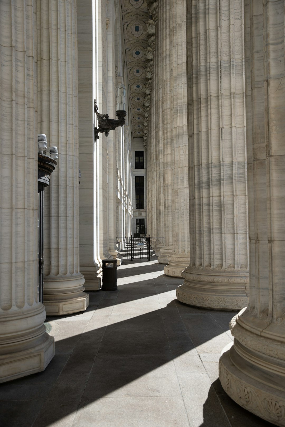 marble-columns-line-a-sunlit-walkway-with-shadows-zcuuvqeq9mg